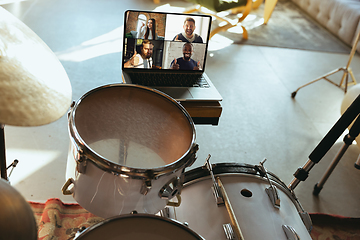 Image showing Caucasian musician playing drumms during online concert or sound-check with the band at home isolated and quarantined, focus on laptop