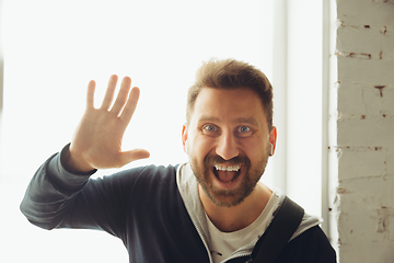 Image showing Caucasian musician greeting audience during concert at home isolated and quarantined, smiling, cheerful