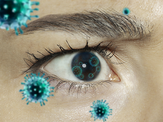 Image showing Close up shoot of a female eye with 3D-illustrated coronavirus models, the way of infecting