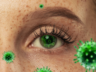 Image showing Close up shoot of a female eye with 3D-illustrated coronavirus models, the way of infecting