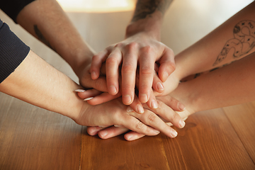 Image showing Close up of caucasian male and female hands, covering one another, team, friendship, business