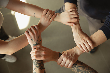 Image showing Close up of caucasian male and female hands, covering one another, team, friendship, business