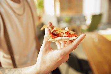 Image showing Close up of male hands holding pizza, eating, proposing