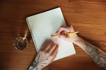 Image showing Close up of male hands writing on an empty paper, education and business concept, top view