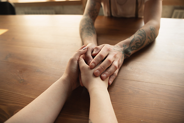 Image showing Loving couple holding hands close-up on wooden background, romantic