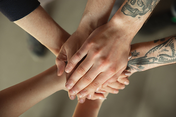 Image showing Close up of caucasian male and female hands, covering one another, team, friendship, business