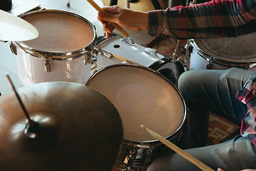 Image showing Caucasian musician playing drumms during online concert with the band at home isolated and quarantined, inspired improvising, close up