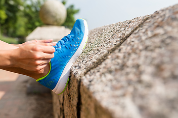 Image showing Woman tying laces for jogging 