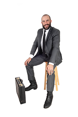 Image showing Business man sitting with his and briefcase