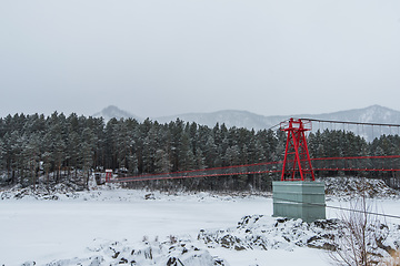 Image showing Suspension hanging bridge above winter frozen river