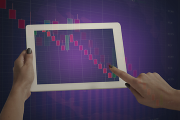 Image showing Hands holding tablet showing graphs going down. Double exposure with graphs, digital. Virus alert, coronavirus pandemic, crisis, unemployment