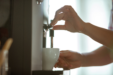 Image showing Close up of female hands making coffee on coffee-machine at home or cafe