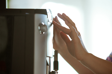 Image showing Close up of female hands making coffee on coffee-machine at home or cafe