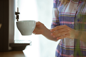 Image showing Close up of female hands making coffee on coffee-machine at home or cafe