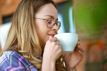 Image showing Close up of beautiful joyful woman drinking coffee at home