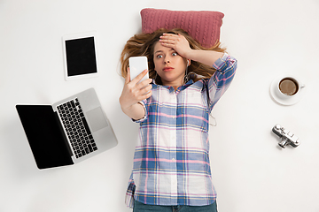 Image showing Emotional caucasian woman using gadgets isolated on white studio background, technologies connecting people. Crazy shocked