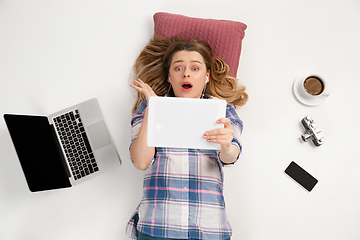 Image showing Emotional caucasian woman using gadgets isolated on white studio background, technologies connecting people. Online shopping, selfie, gaming