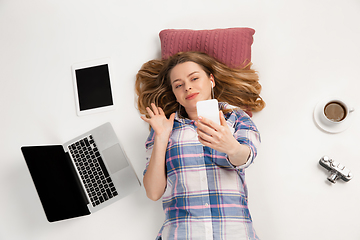 Image showing Emotional caucasian woman using gadgets isolated on white studio background, technologies connecting people. Greeting