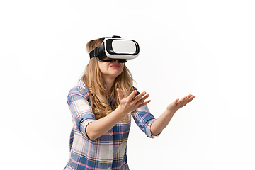 Image showing Emotional caucasian woman using VR-headsed isolated on white studio background, technologies. Scared