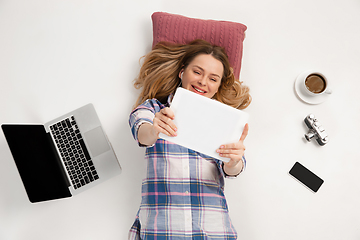 Image showing Emotional caucasian woman using gadgets isolated on white studio background, technologies conncecting people. Online shopping, selfie, gaming