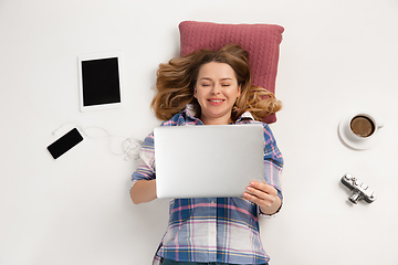 Image showing Emotional caucasian woman using gadgets isolated on white studio background, technologies connecting people. Smiling