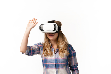 Image showing Emotional caucasian woman using VR-headsed isolated on white studio background, technologies. Greeting