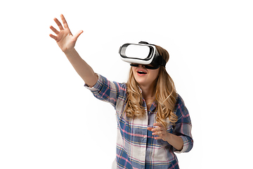 Image showing Emotional caucasian woman using VR-headsed isolated on white studio background, technologies. Touching
