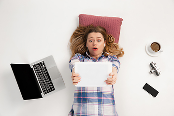 Image showing Emotional caucasian woman using gadgets isolated on white studio background, technologies. Online shopping, selfie, gaming