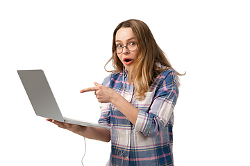 Image showing Emotional caucasian woman using laptop on white studio background, technologies. Shocked pointing