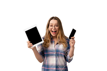 Image showing Emotional caucasian woman using gadgets on white studio background, technologies. Crazy happy shows tablet and smartphone