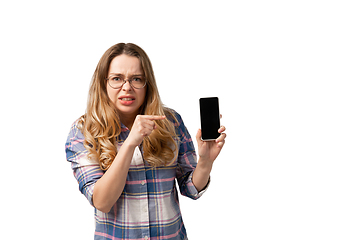 Image showing Emotional caucasian woman using smartphone isolated on white studio background, technologies. Disguasted, pointing