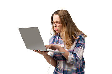 Image showing Emotional caucasian woman using laptop on white studio background, technologies. Focused working