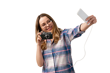 Image showing Emotional caucasian woman using smartphone isolated on white studio background, technologies. Taking selfie with camera