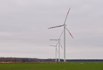 Image showing Wind energy plant under cloudy sky