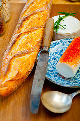 Image showing French cheese and fresh  baguette on a wood cutter