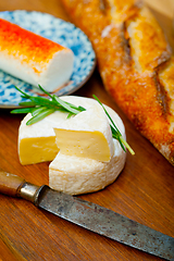 Image showing French cheese and fresh  baguette on a wood cutter