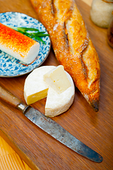 Image showing French cheese and fresh  baguette on a wood cutter