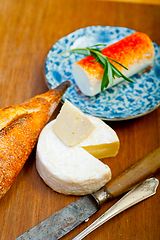 Image showing French cheese and fresh  baguette on a wood cutter