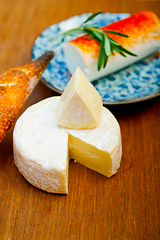 Image showing French cheese and fresh  baguette on a wood cutter