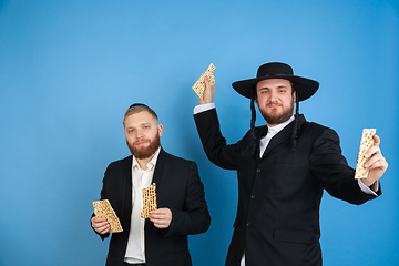 Image showing Portrait of a young orthodox jewish men isolated on blue studio background, meeting the Passover