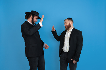 Image showing Portrait of a young orthodox jewish men isolated on blue studio background, meeting the Passover