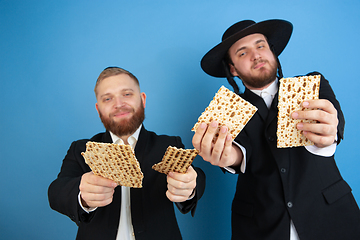 Image showing Portrait of a young orthodox jewish men isolated on blue studio background, meeting the Passover