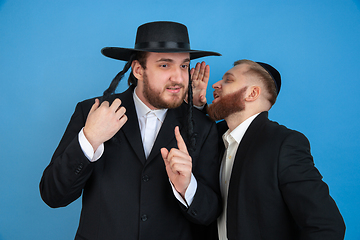 Image showing Portrait of a young orthodox jewish men isolated on blue studio background, meeting the Passover