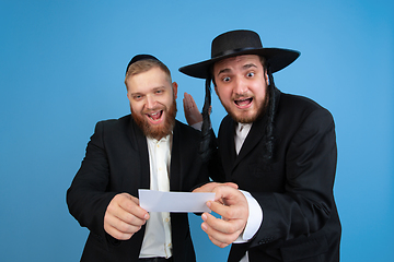 Image showing Portrait of a young orthodox jewish men isolated on blue studio background, meeting the Passover, winners