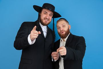 Image showing Portrait of a young orthodox jewish men isolated on blue studio background, meeting the Passover