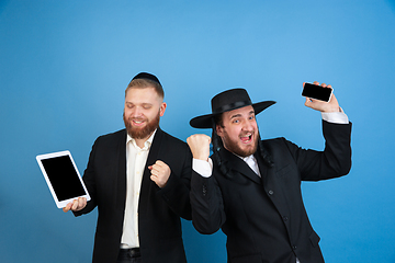 Image showing Portrait of a young orthodox jewish men isolated on blue studio background, meeting the Passover, winners