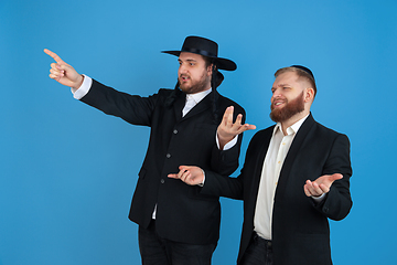 Image showing Portrait of a young orthodox jewish men isolated on blue studio background, meeting the Passover