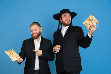 Image showing Portrait of a young orthodox jewish men isolated on blue studio background, meeting the Passover