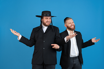 Image showing Portrait of a young orthodox jewish men isolated on blue studio background, meeting the Passover