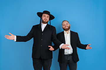 Image showing Portrait of a young orthodox jewish men isolated on blue studio background, meeting the Passover